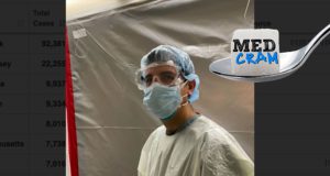 Dr. Ryan Seheult Posts ICU PPE Tutorial on MedCram Physician in scrubs demonstrates donning N95 respirator and gown inside hospital clean zone before entering COVID-19 ICU.