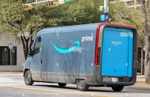 Amazon Halts Non-Essential Shipments Amid Virus Surge Amazon warehouse worker sorts boxes labeled essential items during coronavirus lockdown