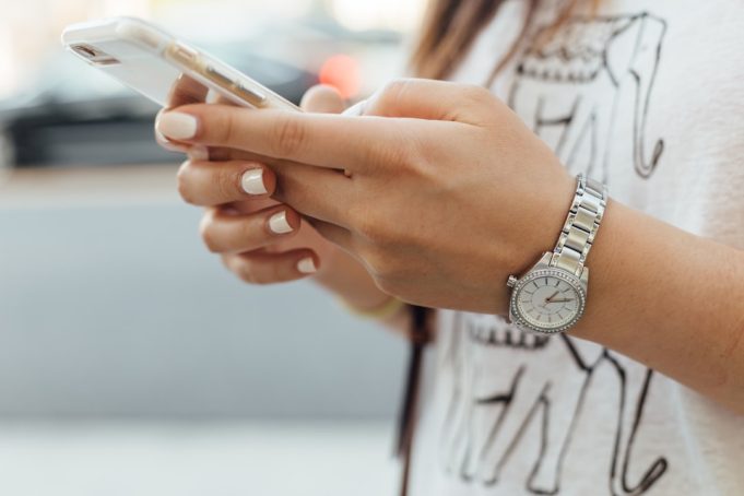 China's quarantine drives mobile game downloads to record 760 million users A person in quarantine holds a smartphone displaying a mobile game, with a window showing a locked-down city street.