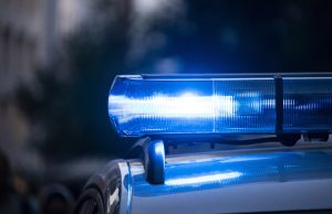 Police Seize KNM Group Documents Over Forged Proxies Police officers carrying boxes of documents out of a corporate office building during a commercial crime investigation.