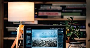 Apple Ships macOS, iOS, and iPadOS 18 on Same Day Apple devices displaying macOS Sequoia, iOS 18, and iPadOS 18 update screens side by side on a desk.