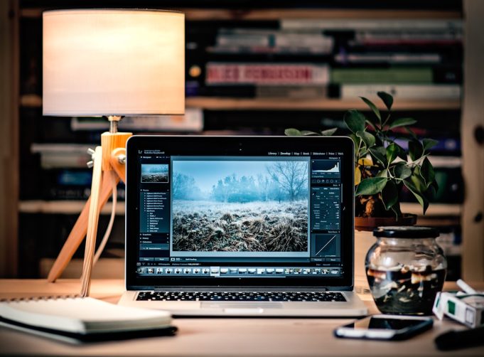 Apple devices displaying macOS Sequoia, iOS 18, and iPadOS 18 update screens side by side on a desk.