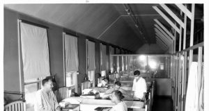 A vial of Eli Lilly's Alzheimer's drug donanemab on a laboratory counter with medical professionals in the background.