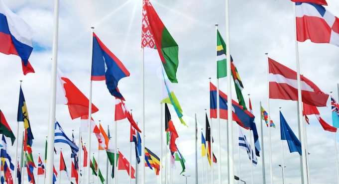 World leaders gather at a conference table during the APEC summit in Lima, Peru, with national flags displayed in the background.