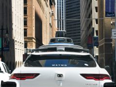 Waymo Runs 500,000 Paid Robotaxi Rides Weekly A Waymo autonomous vehicle drives through a city street with no driver behind the wheel during a paid passenger ride.