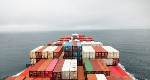 Russian Missile Hits China-Bound Iron Ore Ship A damaged cargo ship with a Liberian flag sits in a Ukrainian port after a missile strike, with smoke rising from the deck.