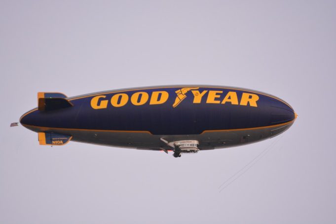 Pilot Injured as São Paulo FC Blimp Crashes into Homes in Osasco Suburb A damaged blimp envelope lies crumpled on a residential street in Osasco, with houses and power lines nearby.