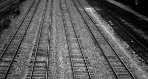 Seven Suspected Immigrants Die in Texas Train Boxcar A sealed train boxcar sits on tracks in a Texas rail yard, surrounded by emergency vehicles and investigators.