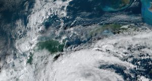 Tropical Storm Sara Hits Belize After Flooding Honduras Satellite image of Tropical Storm Sara approaching the coast of Belize with heavy cloud cover and rain bands.