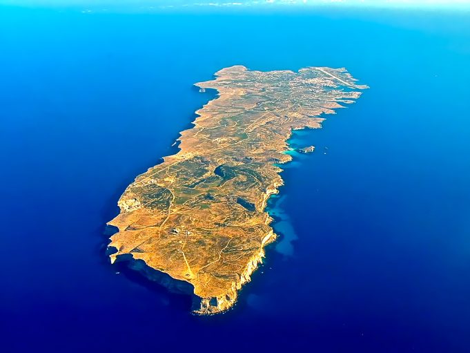Boat Carrying Migrants Capsizes Off Italian Coast, Killing Twenty-Six People Rescue boats search near a capsized migrant vessel off the coast of Lampedusa, with emergency crews in the Mediterranean Sea.