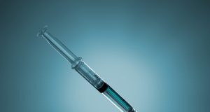 A person holding a Mounjaro injector pen, preparing for a subcutaneous injection in a home setting.