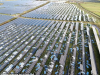 Solar panels on a rooftop in the UK under bright sunlight, generating electricity for the grid.