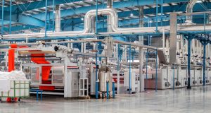 GlobalFoundries Invests US$6B in Chip Plants Construction workers at a GlobalFoundries semiconductor fabrication plant site in Singapore, with cranes and building materials visible.
