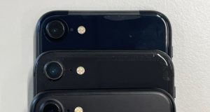 Apple Unveils iPhone 15 With USB-C Switch Apple CEO holds new iPhone 15 on stage, USB-C port visible under studio lights at Apple Park event.