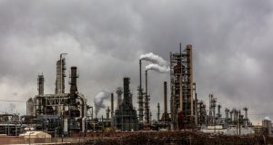 Factory worker in protective gear inspects empty ethanol storage tanks at a Malaysian chemical processing plant.