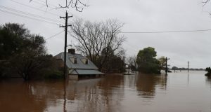 Pakistan Monsoon Floods Kill 55, Including 8 Children Floodwaters engulf a residential area in Pakistan during the monsoon season, with submerged homes and debris visible.