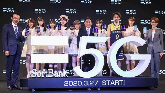 SoftBank store front in Tokyo with 5G banner and customers testing new phones on launch day