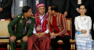 Thai officials greet Myanmar military and opposition delegations seated at a long table for peace negotiations.