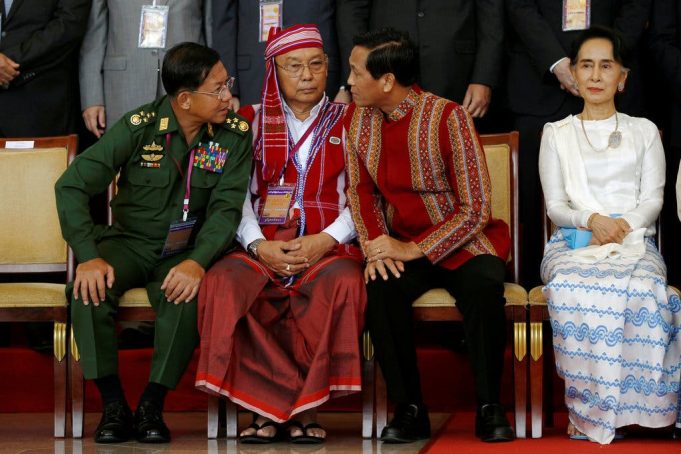 Thailand Myanmar Peace Talks Mediation Thai officials greet Myanmar military and opposition delegations seated at a long table for peace negotiations.