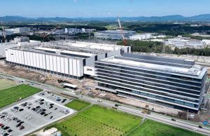TSMC and Japanese officials shake hands in Tokyo before signing a $338 million chip plant agreement.
