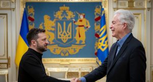 CIA Director William Burns and President Zelenskyy shake hands inside a Kyiv government building amid tight security.