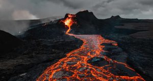 Phivolcs Warns Taal Eruption May Trigger Volcanic Tsunami Taal Volcano erupts steam and ash over a lake, with nearby towns visible on the shoreline.