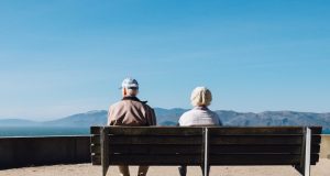 FDA Approves Donanemab Despite 36.8% Brain Swelling Risk A doctor reviewing brain scan images on a monitor while an elderly patient sits nearby in a clinic examining room.