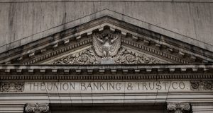 UBS Pays $1.5B Penalties for LIBOR Fraud UBS bank building exterior with traders working at desks in a financial district