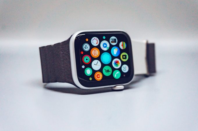 Apple Watch User Base Reaches 115 Million Since 2015 Launch A person wearing an Apple Watch on their wrist, checking the screen in a well-lit room