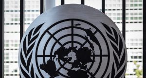 Sixth Briton in Row to Lead UN Humanitarian Office Thomas Fletcher stands at a podium with UN logo, preparing to lead humanitarian coordination efforts in October 2024.